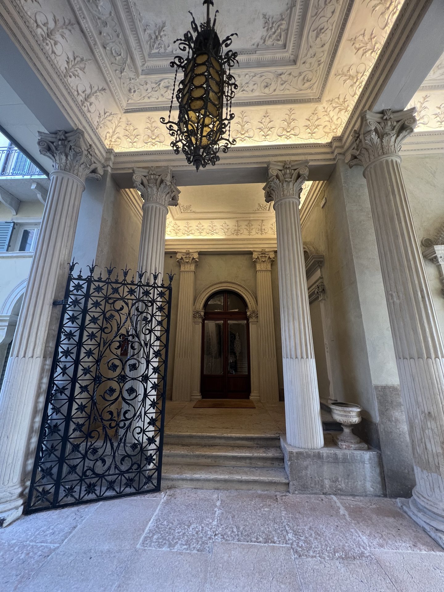 Androne monumentale con colonne corinzie e lampadario in ferro battuto